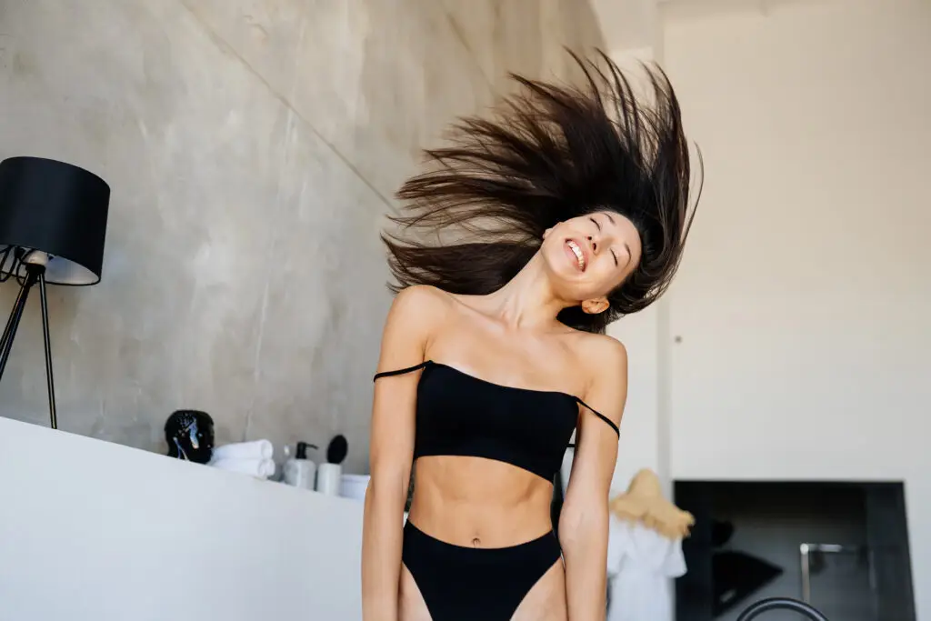 Woman with healthy, shiny hair in a bright bathroom