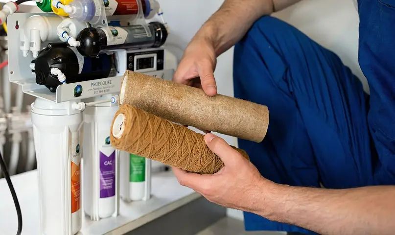 Technician replacing sediment filter cartridges in an RO system