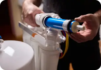 Technician installing an RO membrane in a filtration system