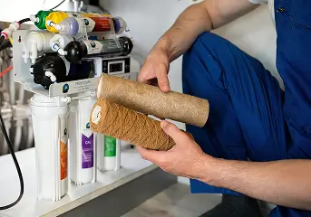 Technician replacing sediment filter cartridges